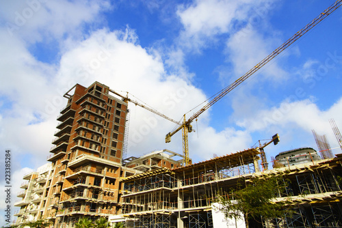 Construction of a high-rise building with a crane. Building construction using formwork. The construction crane and the building against the blue sky.