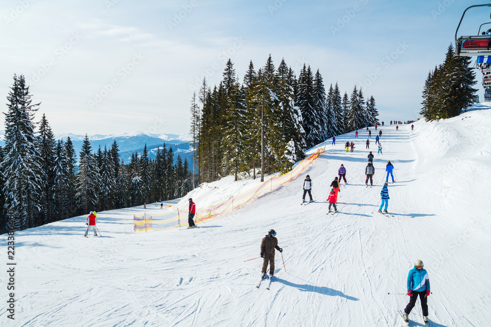 Winter holidays in the mountains. Mountain-skiing resort in the Carpathians.several skiers on a snowy road