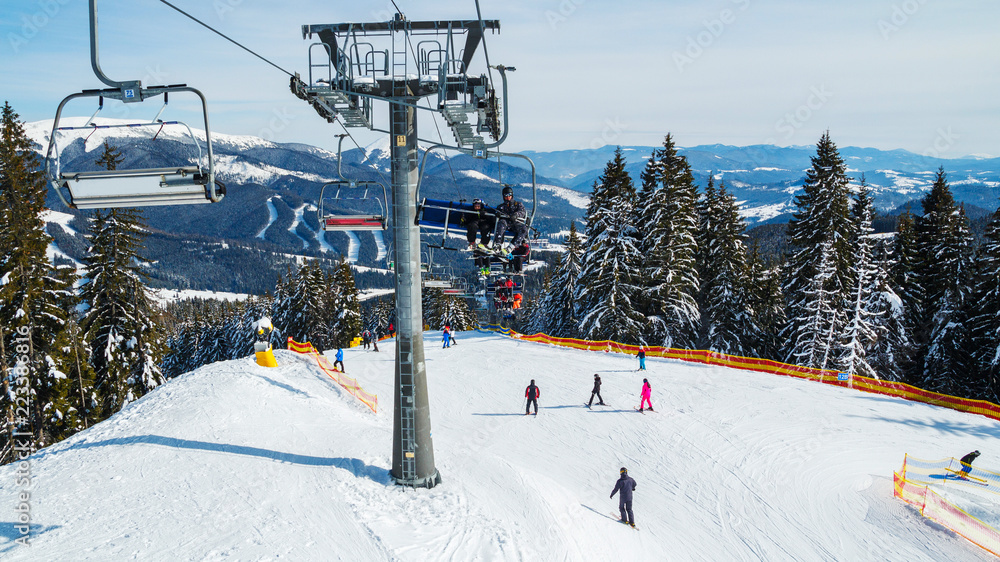 Winter holidays in the mountains. Mountain-skiing resort in the Carpathians.several skiers on a snowy road Winter holidays in the mountains. Mountain-skiing resort in the Carpathians.several skiers on a snowy road