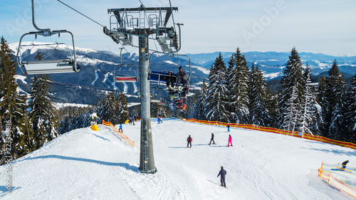 Winter holidays in the mountains. Mountain-skiing resort in the Carpathians.several skiers on a snowy road