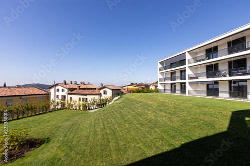 Exterior modern white condominium building with lots of lawn,