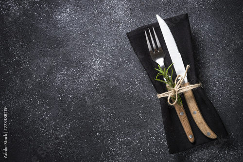 Cutlery and napkin on stone table top view.