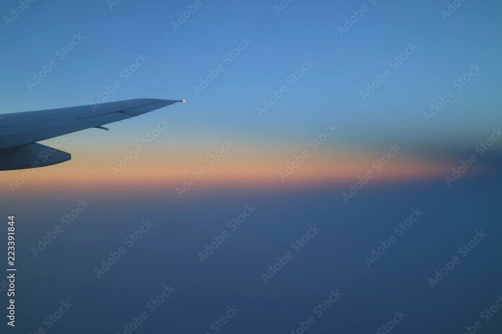 Breathtaking color layer of sunrise sky with airplane wing view from the plane window Breathtaking color layer of sunrise sky with airplane wing view from the plane window