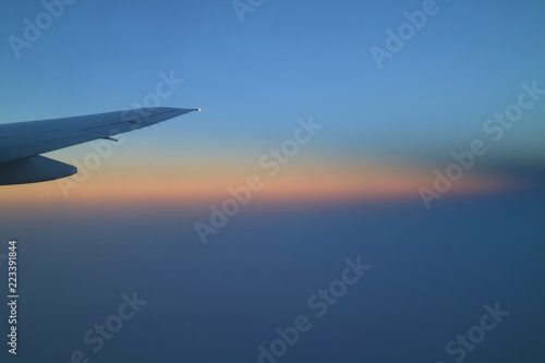 Breathtaking color layer of sunrise sky with airplane wing view from the plane window 