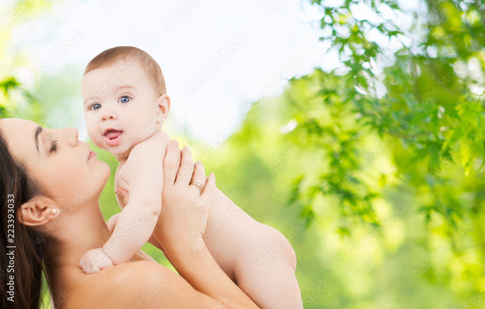 family and motherhood concept - happy smiling young mother with little baby over green natural background