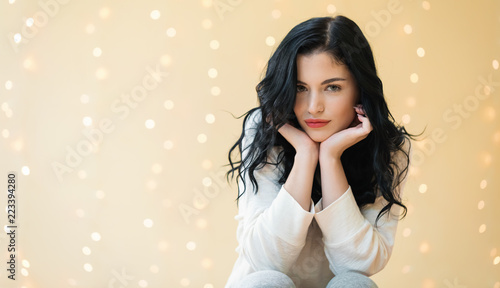 Portrait of a young woman on a shiny light background