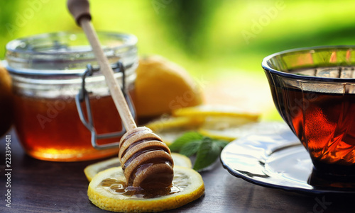 Tea with lemon and mint in nature. A cup of hot mint tea with le