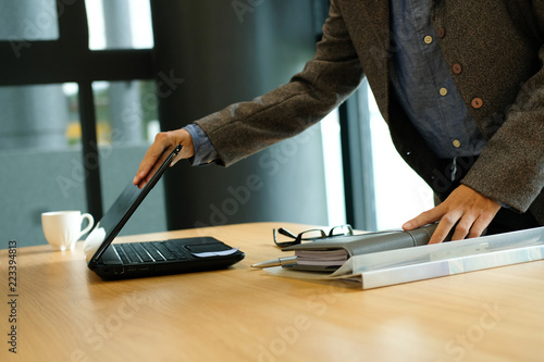 Photos woman holding notebook & closing computer after finishing work