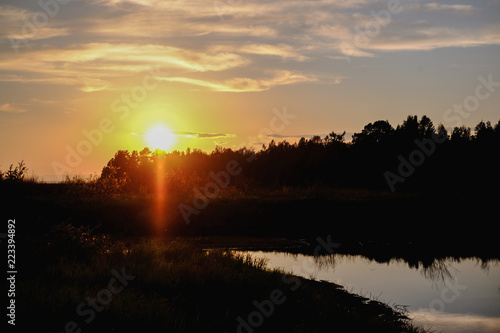 Landscape at sunset with reflection in the water of trees