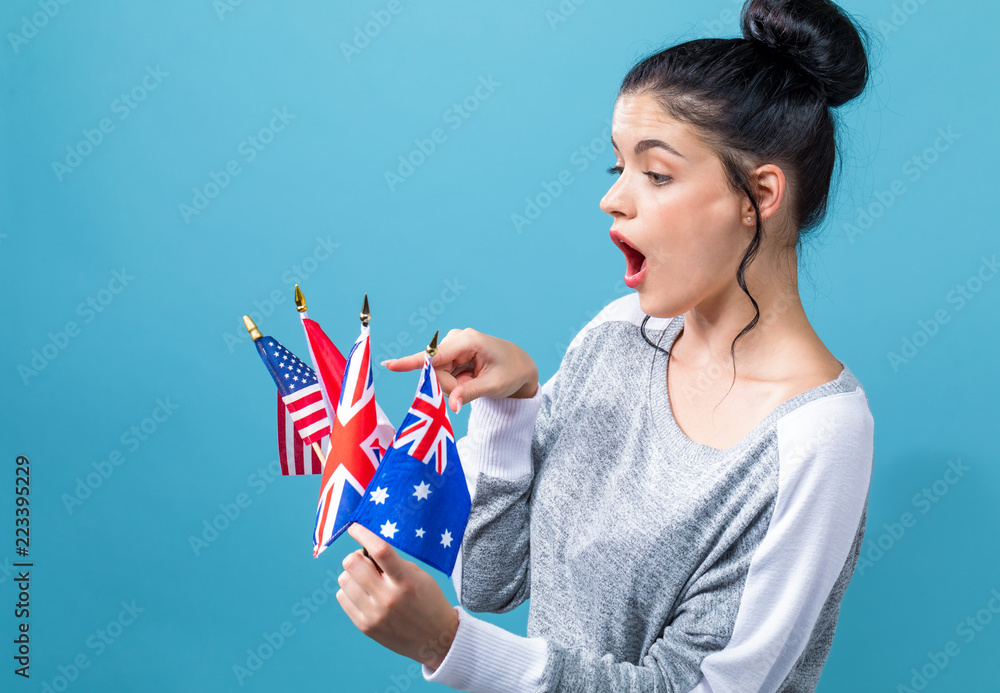 Young woman with learn English theme with the flags of English speaking countries on a blue