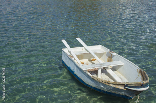 Pserimos port, boat on the blue water. © Pikat