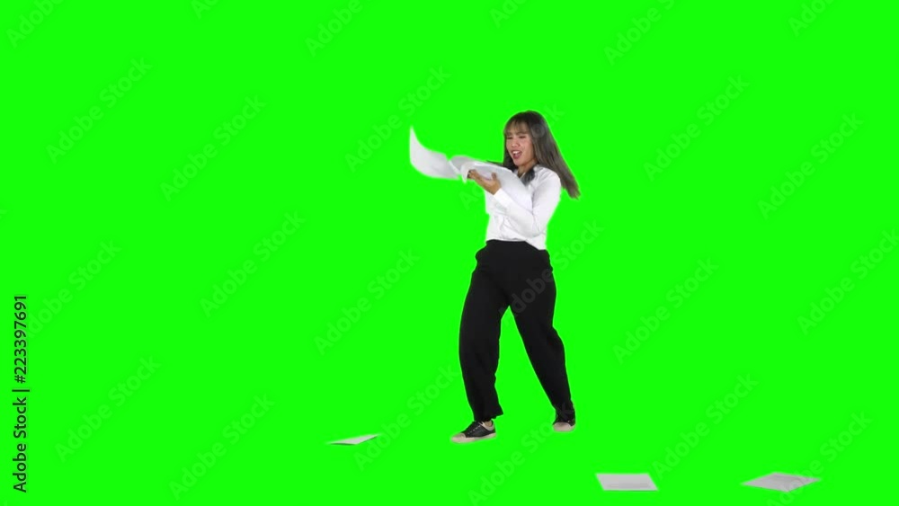 Cheerful young businesswoman celebrating her success by throwing documents in the studio, shot in 4k resolution with green screen background Cheerful young businesswoman celebrating her success by throwing documents in the studio, shot in 4k resolution with green screen background