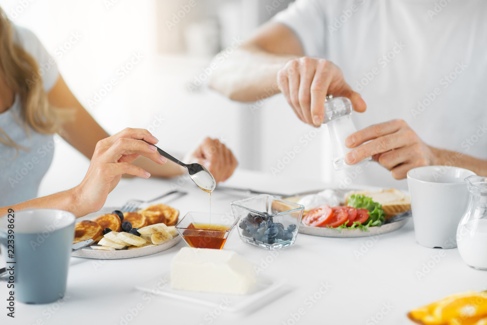 food and eating concept - close up of couple having breakfast at home