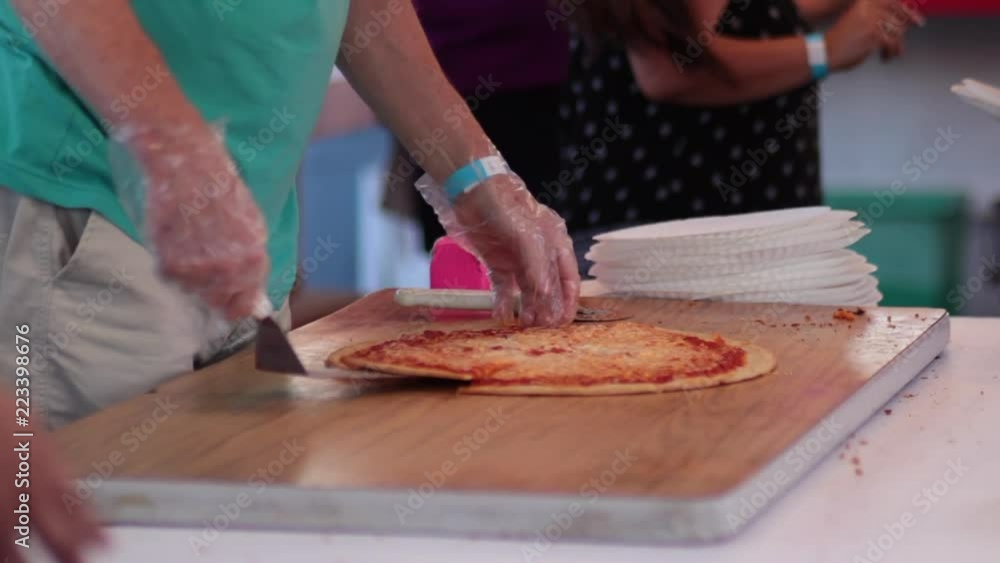 Cutting pizza into slices and serving close up carnival Cutting pizza into slices and serving close up carnival