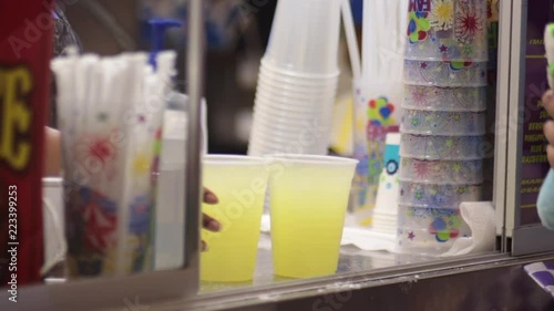 Person being served lemonaid out of carnival cart editorial photo