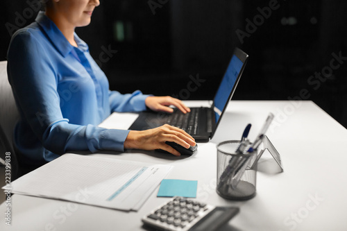 business, people and technology concept - close up of businesswoman using computer mouse for laptop