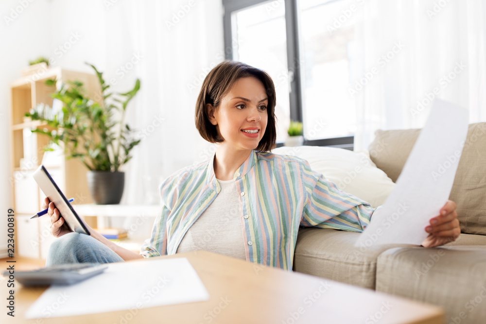 business, savings, finances and people concept - woman with tablet pc, papers and calculator at home business, savings, finances and people concept - woman with tablet pc, papers and calculator at home