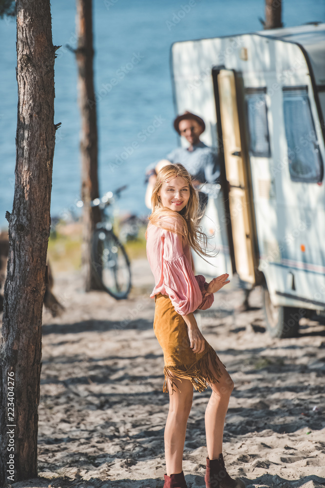 attractive young woman dancing while man playing guitar near campervan