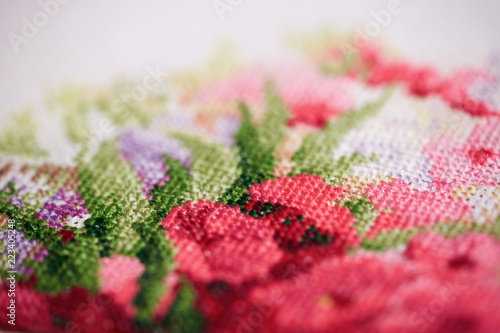 Obraz na plátne Close up of a fragment of a cross-stitch embroidery with flowers.