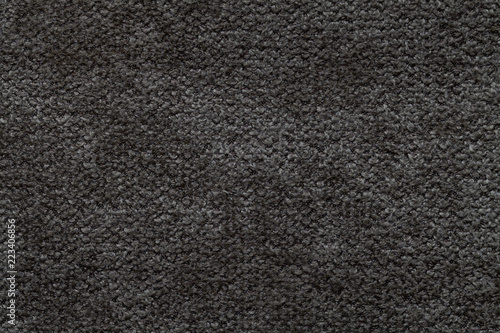 Black fluffy background of soft, fleecy cloth. Texture of light nappy textile, closeup.