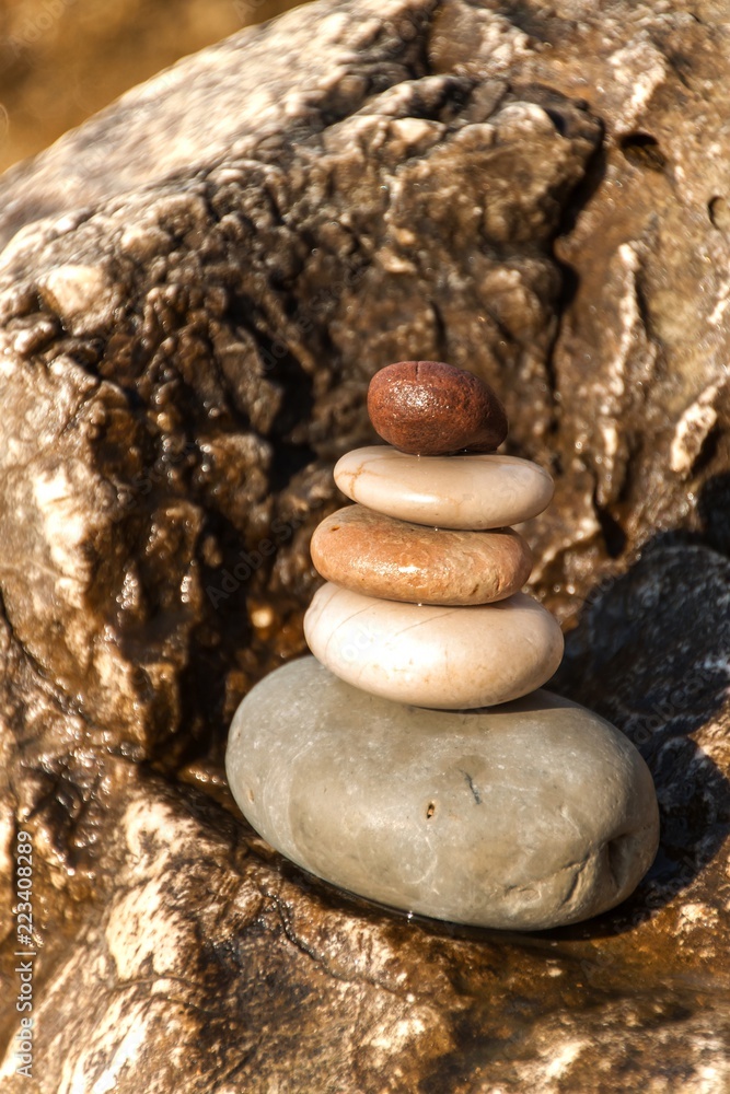 Pile of pebbles on the sea front on a beautiful day. Pebble stack on the seashore. Stone pyramid. Balanced Zen stones. Pile of pebbles on the sea front on a beautiful day. Pebble stack on the seashore. Stone pyramid. Balanced Zen stones.