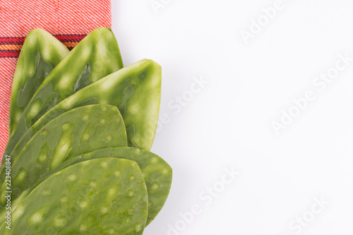 Fotografie Nopales crudos sobre trapo de cocina y superficie blanca con espacio para integr
