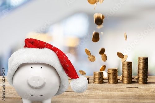 Piggy bank in christmas hat and coins