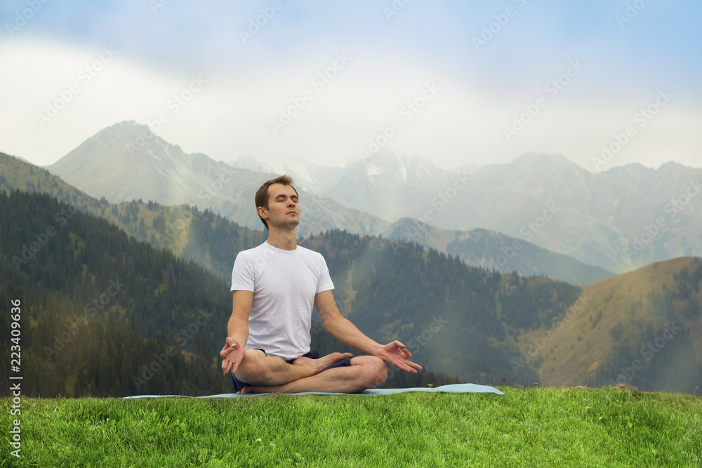 Young man in meditation. Outdoor yoga in mountains