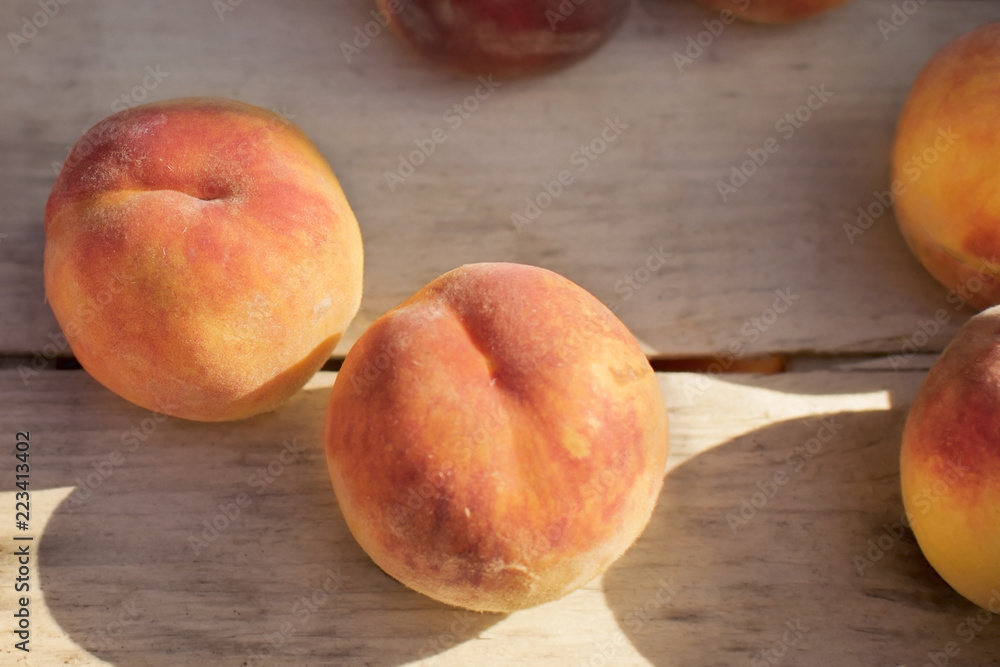 two peaches lie in a wooden box in the sun's rays two peaches lie in a wooden box in the sun's rays