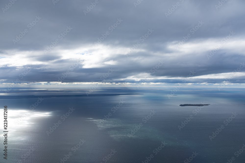 Obraz premium Aerial view from plane of sea and cloud with reflections near Punta Arenaa, Patagonia, Chile 