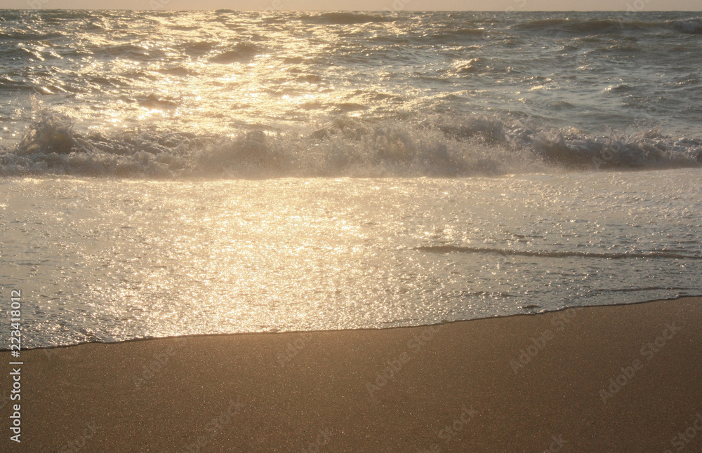 Sea waves and sand. Sunset and evening sun. Summer