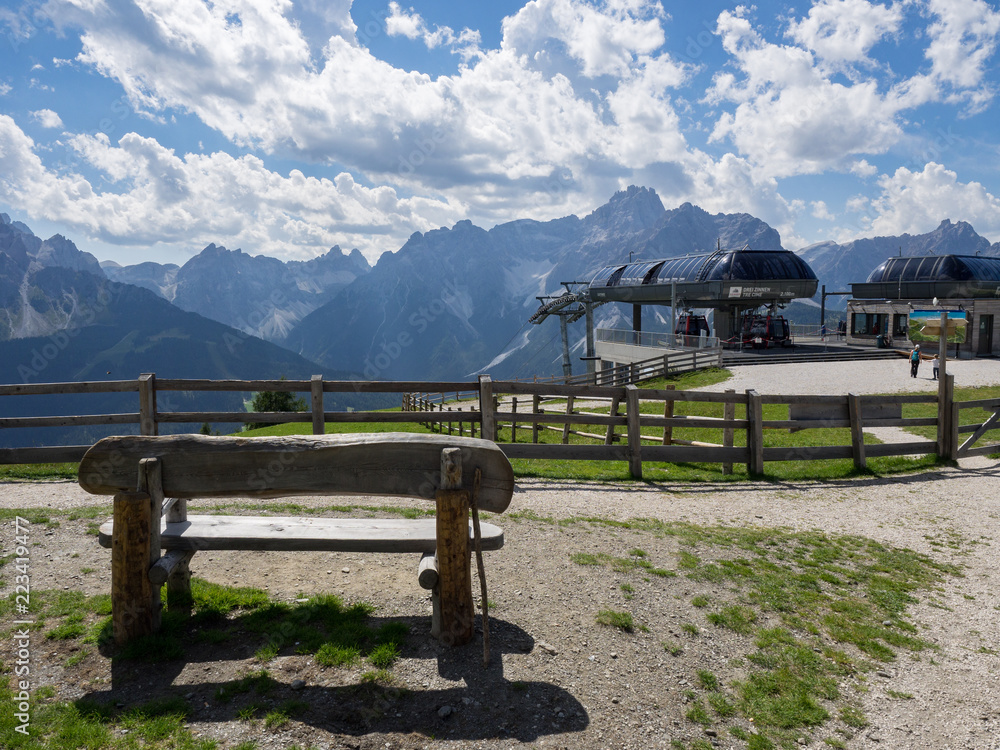 Hölzerne Sitzbank vor Gebirge an der 3 Zinnen Bahn Bergstation, Südtirol, Italien