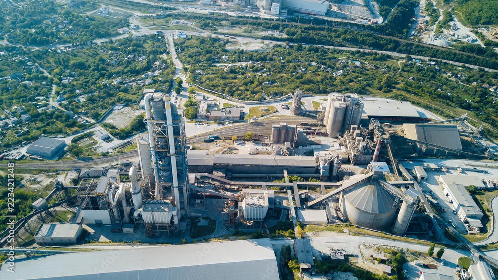 Fototapeta premium Aerial view of cement manufacturing plant. Concept of buildings at the factory, steel pipes, giants.