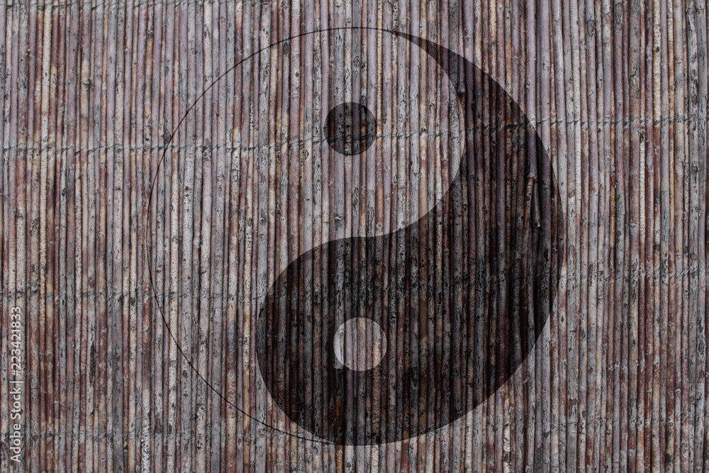 Chinese yin yang sign on a background on a mat with sticks Chinese yin yang sign on a background on a mat with sticks