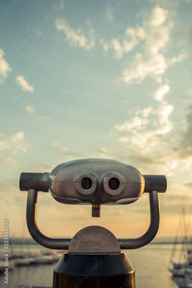 Sunrise in the port through binoculars at the viewing platform view of the sea with yachts overlooking the horizon
