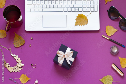 Autumn purple fashion business flat lay with yellow fall leaves and a gift for Thanksgiving day. Top view beauty composition