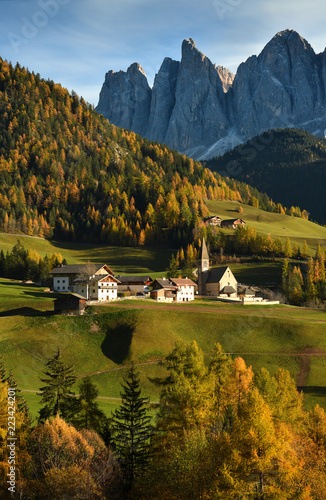 Santa Magdalena village in Val di Funes on the italian Dolomites. Autumnal view of the valley with colorful trees and Odle Dolomites mountain group on the background. Italy.