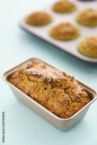 Freshly baked carrot cake and muffins in baking trays. Blue background, high resolution