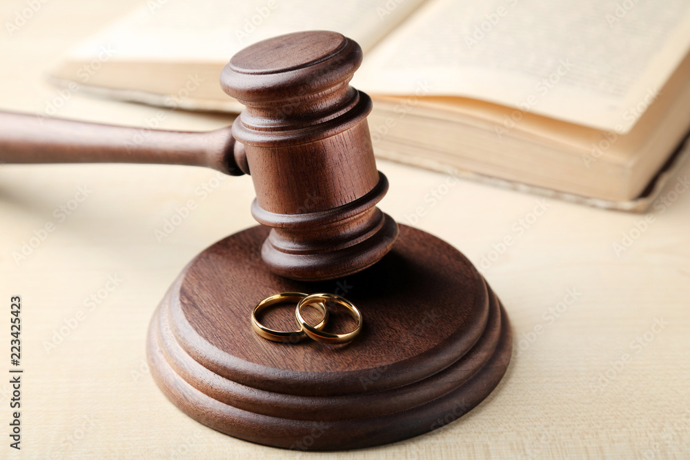 Judge gavel with wedding rings on wooden table Judge gavel with wedding rings on wooden table