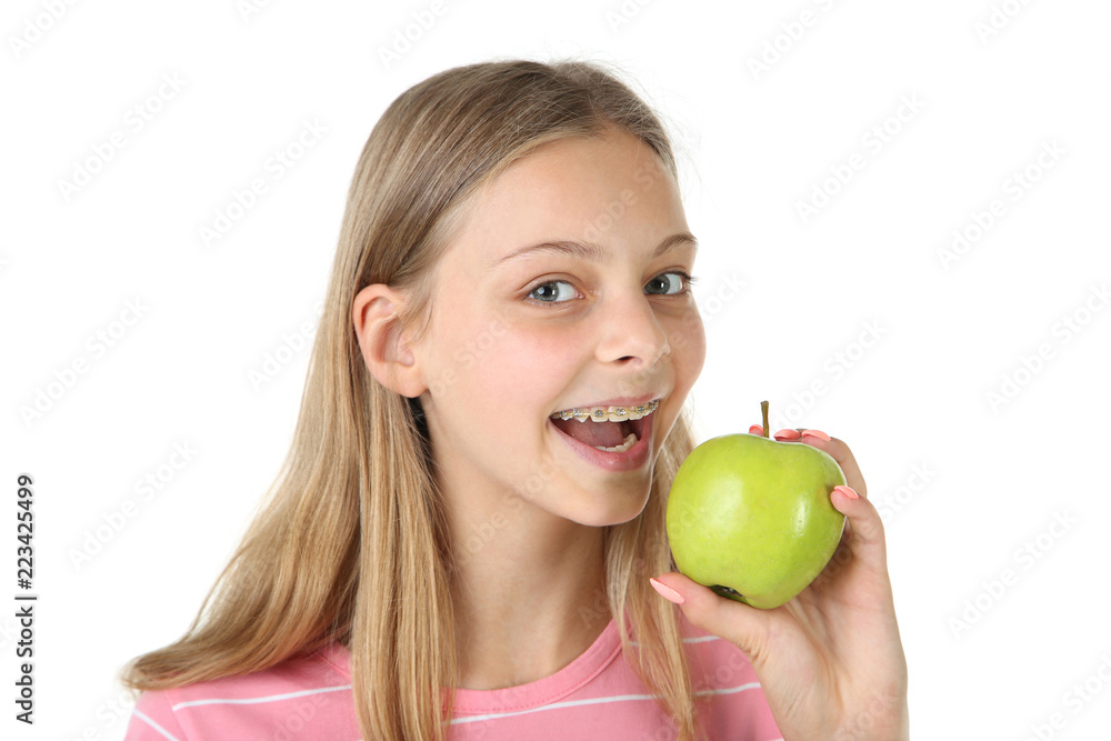 Young smiling girl with dental braces and green apple on white background Young smiling girl with dental braces and green apple on white background