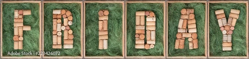 Word Friday made of wine corks on green background in wooden box