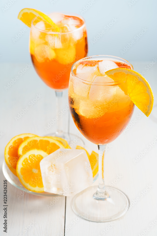 Aperol Spritz served with an orange slice in wine glasses. White ...