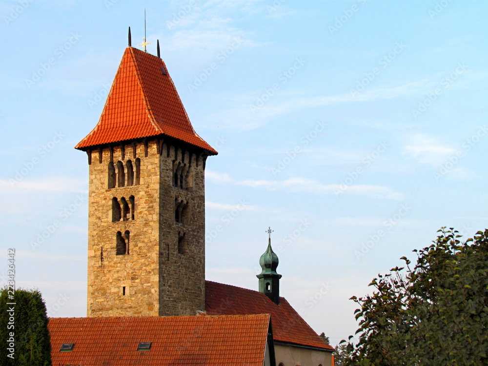 Romanesque tower and part of the roof of a rural church in the village of Chrenovice, horizontal shot, ancient building