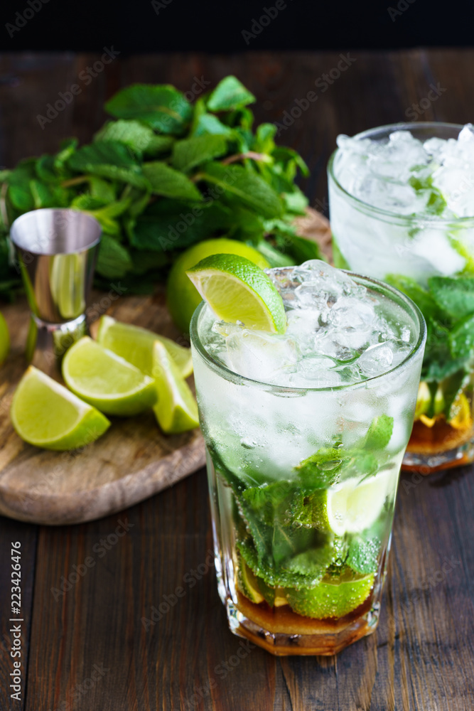 Dirty mojito and ingredients (fresh mint, sliced lime) served on a dark wooden board. High resolution. Dirty mojito and ingredients (fresh mint, sliced lime) served on a dark wooden board. High resolution.