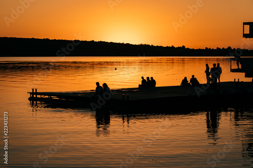 People rest on the river bank. Sunset