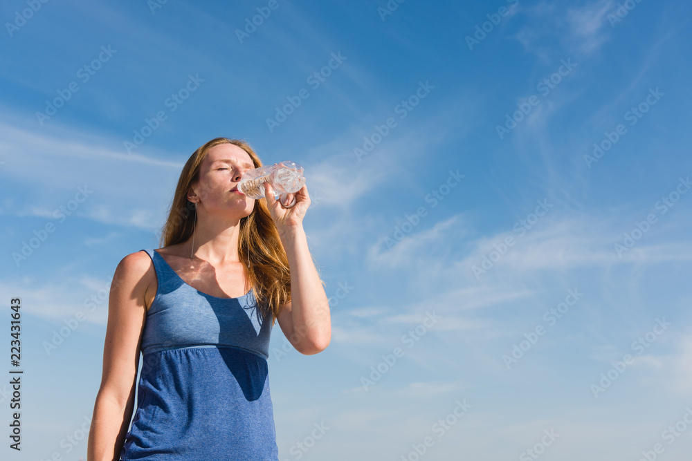 Woman at sky background drink water outdoors Woman at sky background drink water outdoors