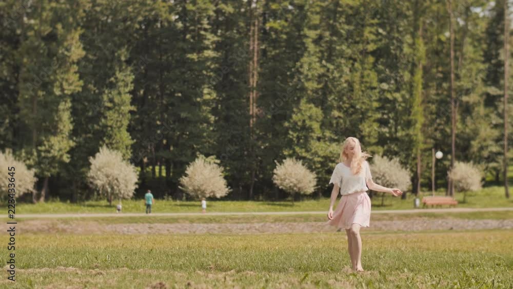 A happy young russian girl is running in the city park. A happy young russian girl is running in the city park.