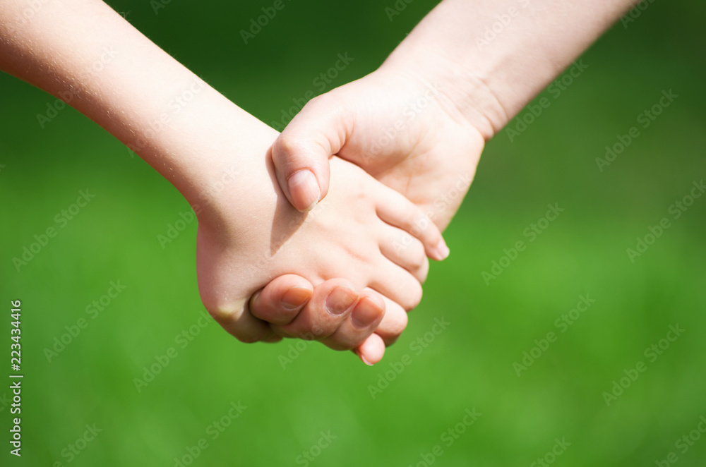 Mother holding a hand of his son in summer day outdoors Mother holding a hand of his son in summer day outdoors