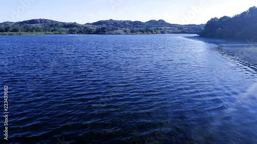 walking over clear water lake with hydrilla reaching to surface. photo