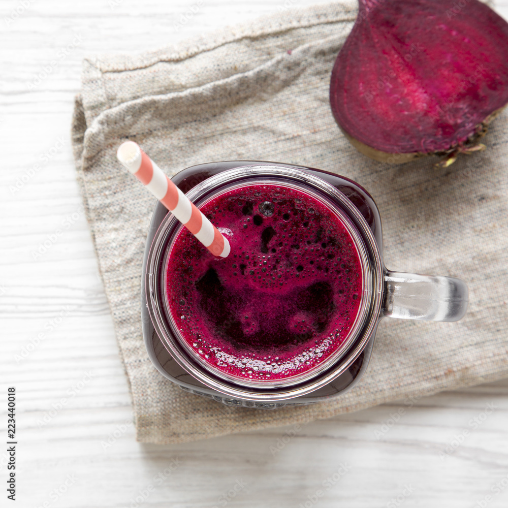 Beetroot smoothie in glass jar mug on a white wooden table, top view. Flat lay, overhead. Close-up. Beetroot smoothie in glass jar mug on a white wooden table, top view. Flat lay, overhead. Close-up.